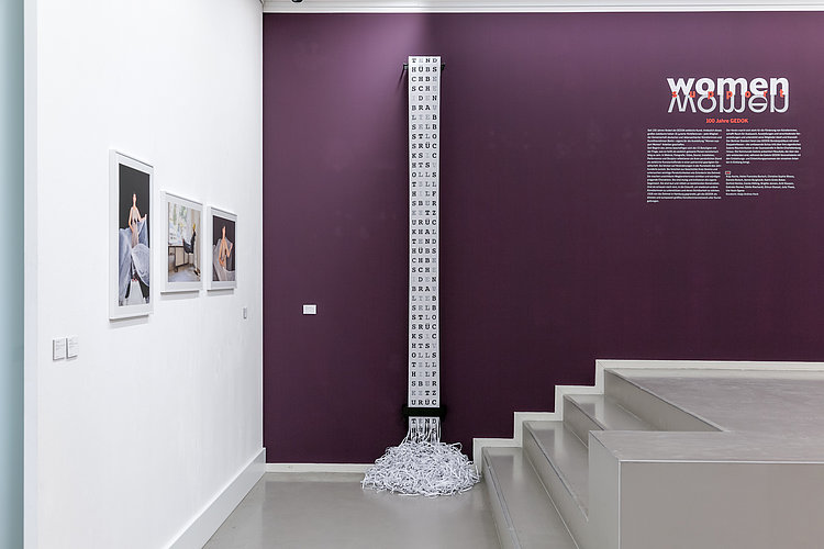 Ansicht der Ausstellung "Women Support Women - 100 Jahre GEDOK". Werk: Konditionierung von Anja Asche. Werke aus der Serie Mutti putzt nicht mehr von Carola Hölting: Handwerkergöttin I, Frau mit Goldhelm, Auriga. Foto von Andree Thielemann. 