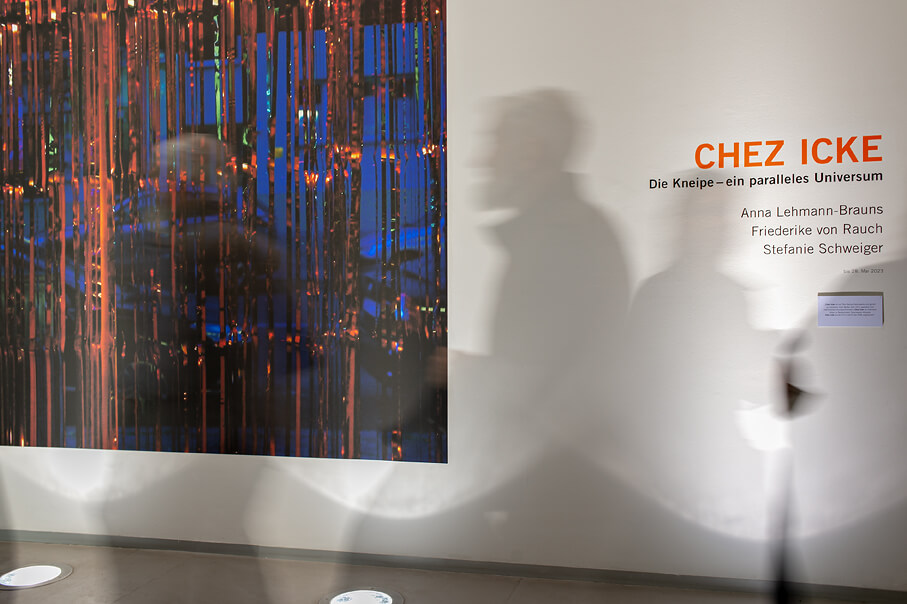 Momentaufnahme der Eröffnungsveranstaltung der Ausstellung "Chez Icke" mit Schattenwürfen der Ausstellungsbesucher