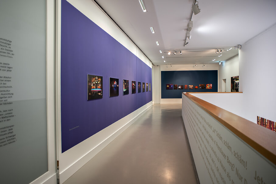 Ansicht der Ausstellung "Chez Icke" mit Fotografien zur linken Seite und einem Zitat zur rechten Seite